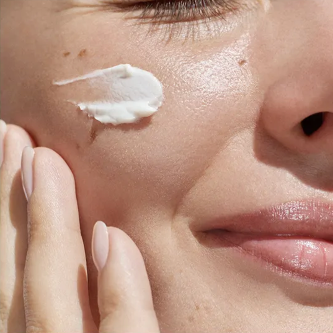 Close-up of a person applying cream to their face
