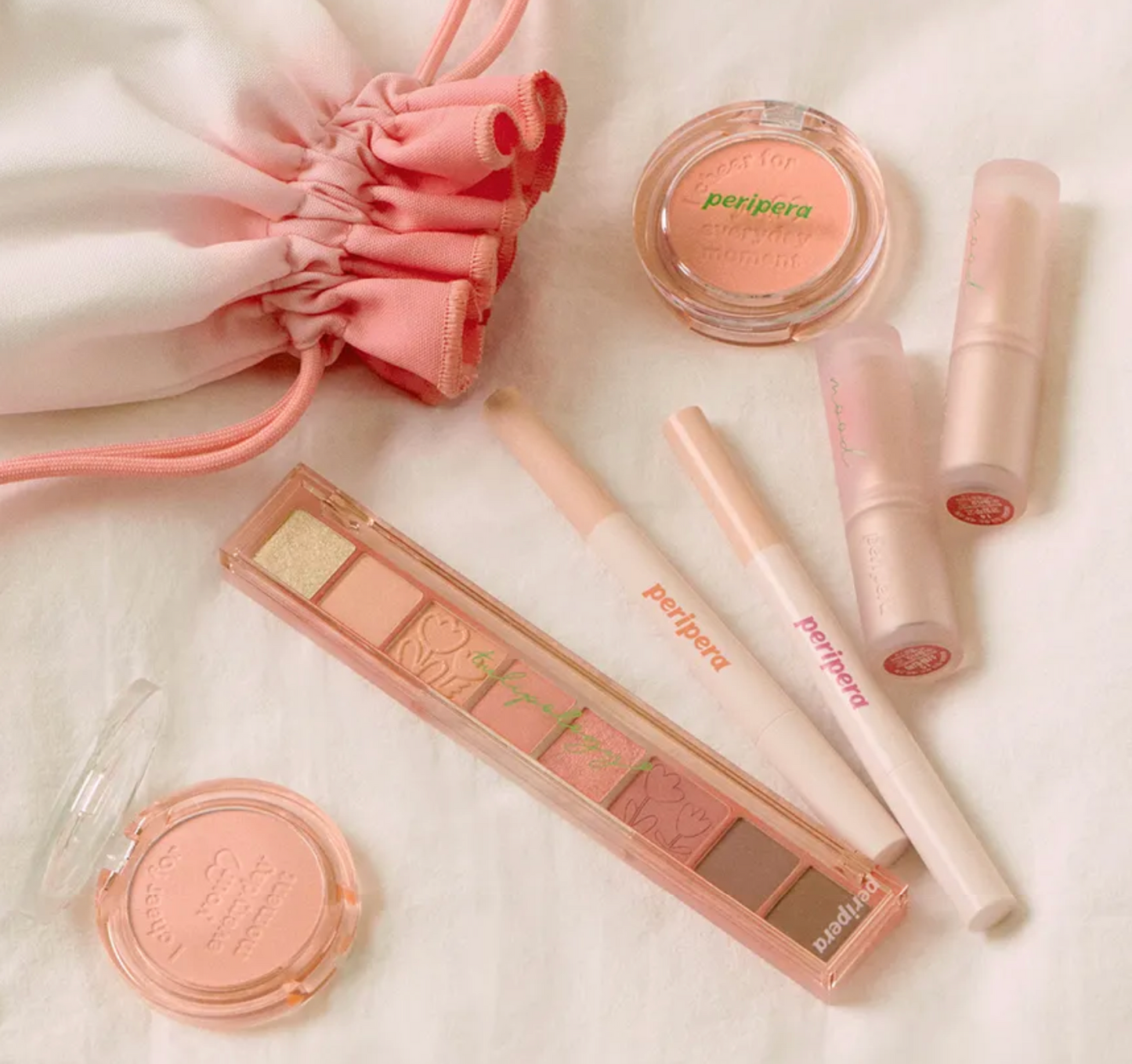 Peripera makeup products including eyeshadow palette, lip gloss, and lip liner on a light background