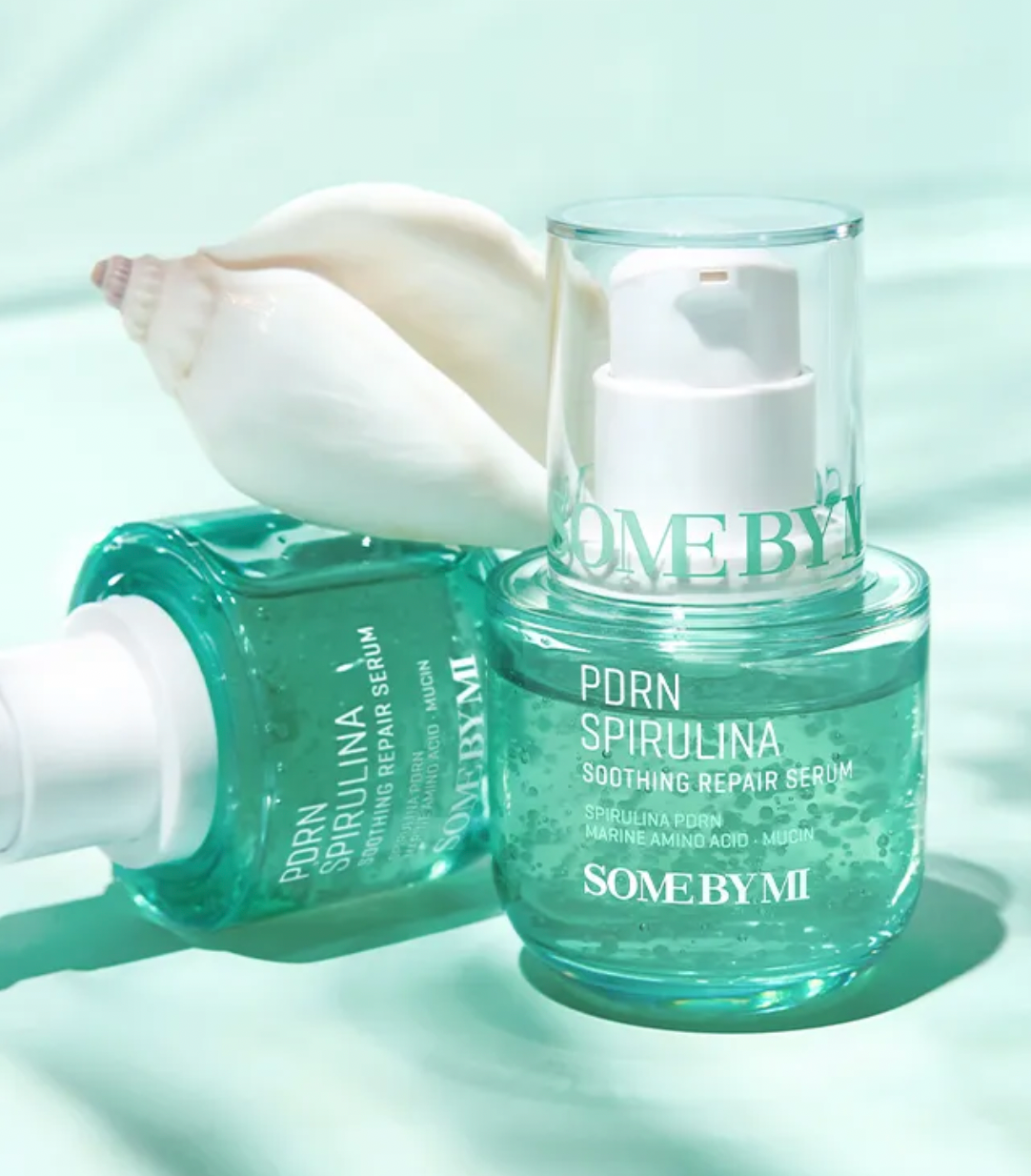 Two bottles of 'Some by Mi' PDRN Spirulina Soothing Repair Serum on a light green background