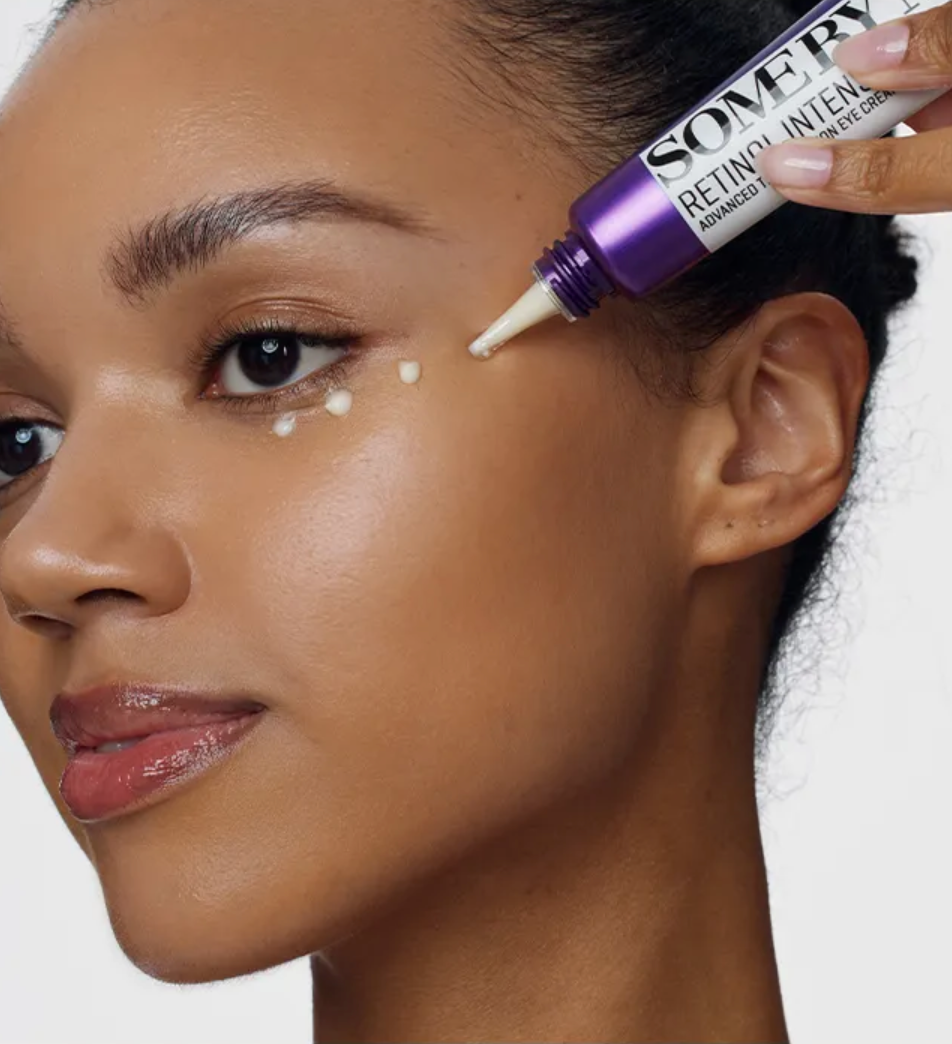 Person applying a cosmetic product to their face with a close-up of the product.