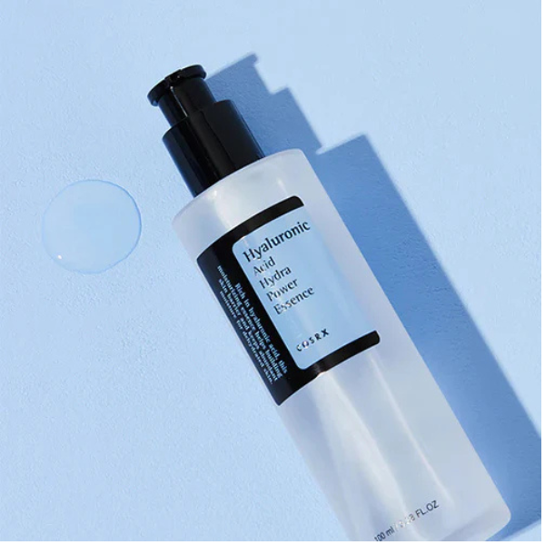 Skincare bottle labeled 'Hyaluronic Acid Hydra Power Essence' on a light blue background