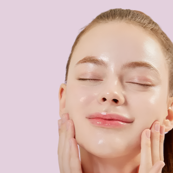 Close-up of a person with their eyes closed, touching their face against a light pink background