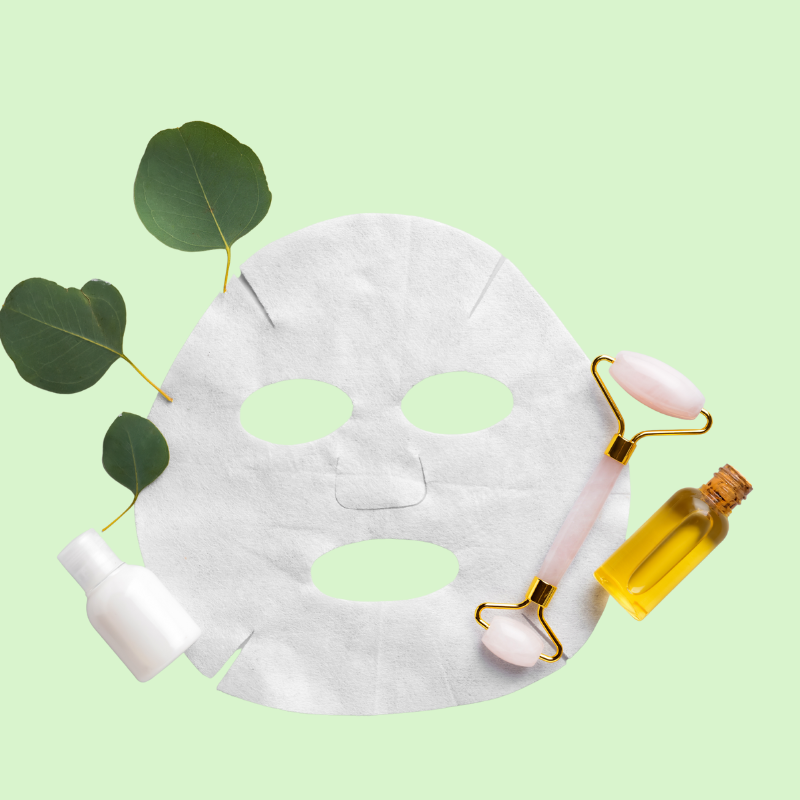 Skincare products including a sheet mask, roller, and bottles on a light green background
