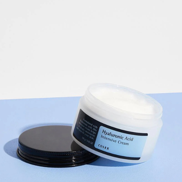 CosRX Hyaluronic Acid Intensive Cream jar on a light blue background