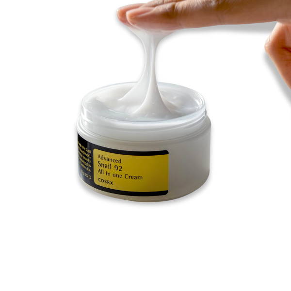 COSRX cream jar with a hand scooping out cream on a white background