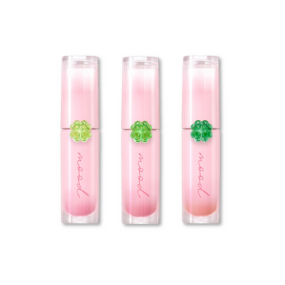 Three pink lip glosses with a green gem in the center on a white background