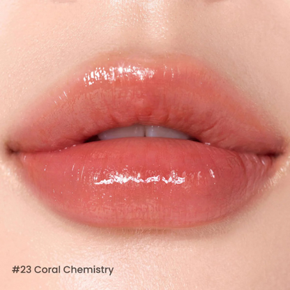 Close-up of lips wearing a glossy coral lipstick with '23 Coral Chemistry' text.