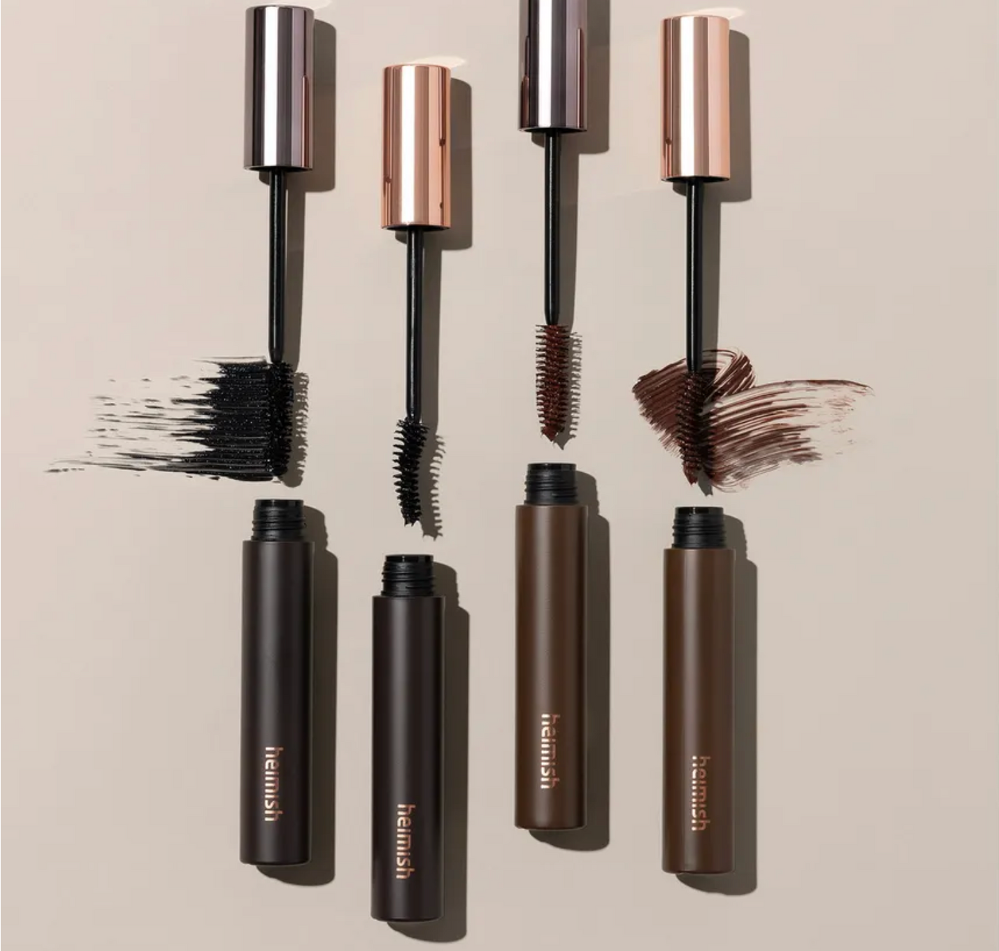 Set of Rebusi mascara tubes with brushes on a beige background
