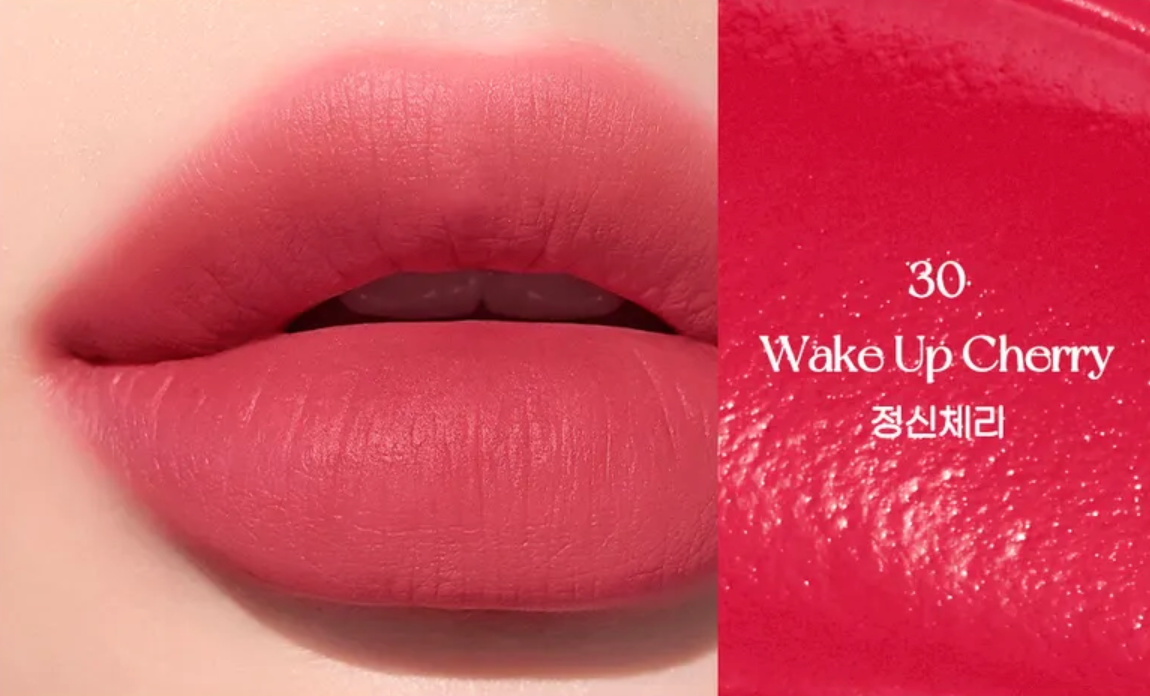 Close-up of a lip with a pink lipstick shade labeled '30 Wake Up Cherry' on a beige background.