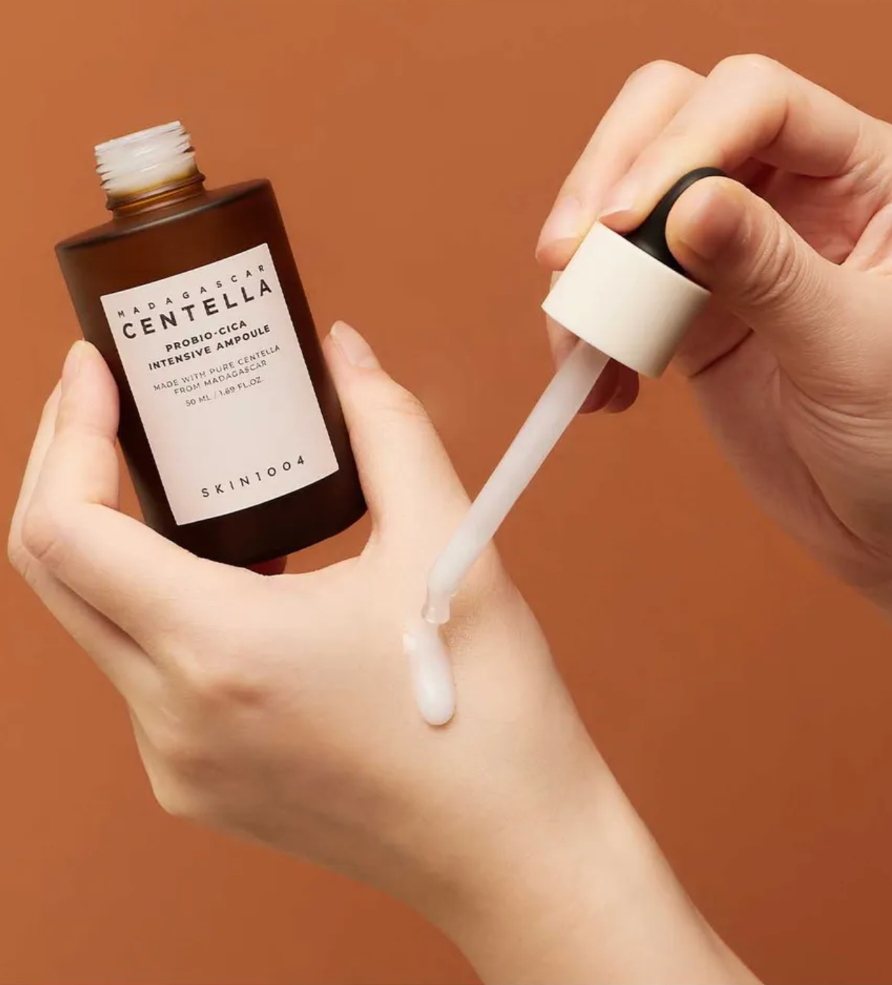 Skintouch Centella bottle with dropper on a brown background