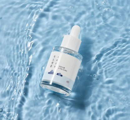 Skincare dropper bottle on water with a blue background