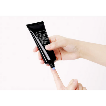 Hand holding a black cosmetic tube with visible text on a white background