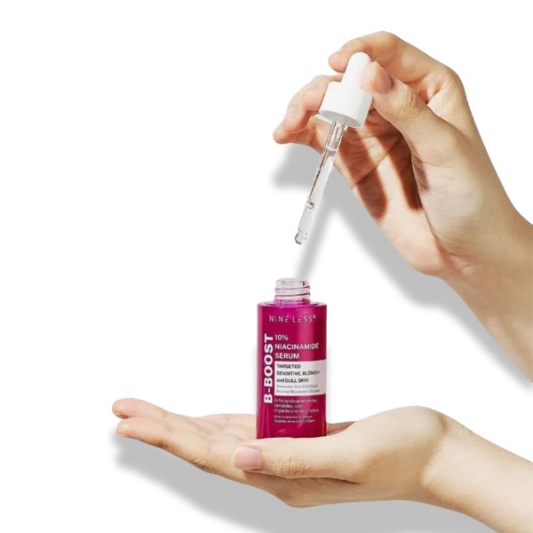 Hand holding a pink serum bottle with a dropper on a white background