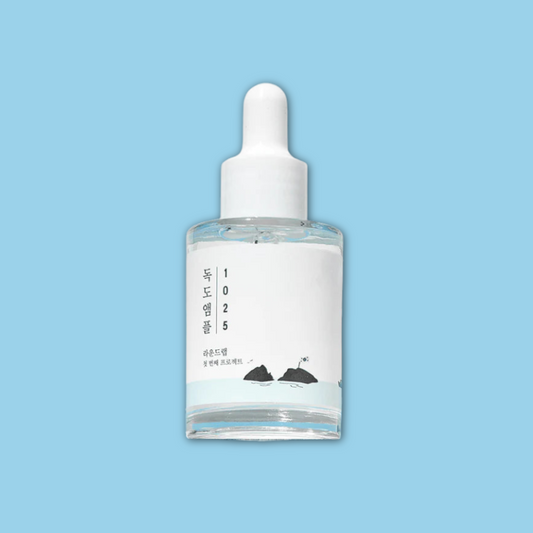 Skincare dropper bottle with a white label on a light blue background