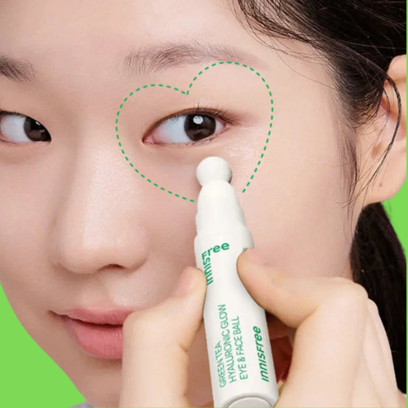 Person applying a cosmetic product to their eye with a close-up of the product labeled 'Free Innisfree'.