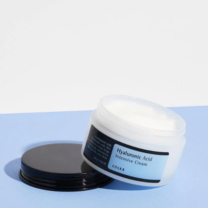 CosRX Hyaluronic Acid Intensive Cream jar on a light blue background